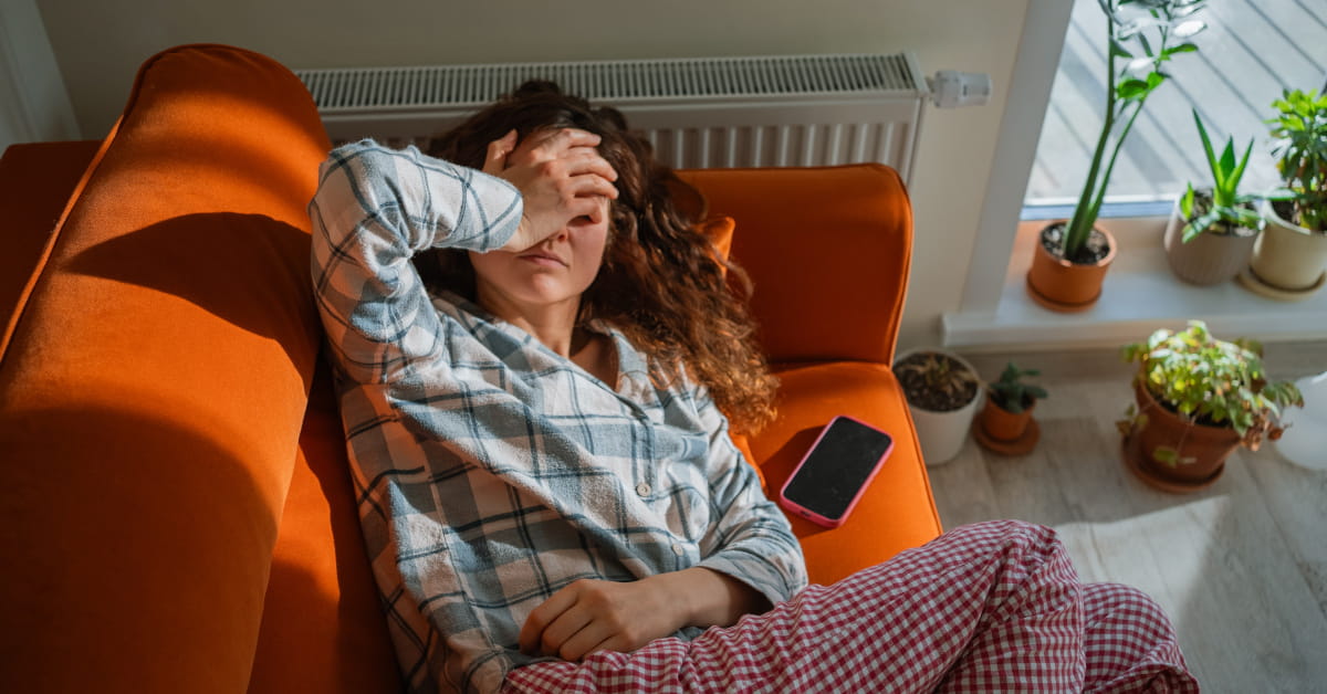 Donna stesa sul divano con il mal di testa