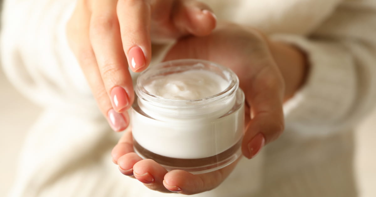 Donna che tiene in mano un barattolo di crema viso