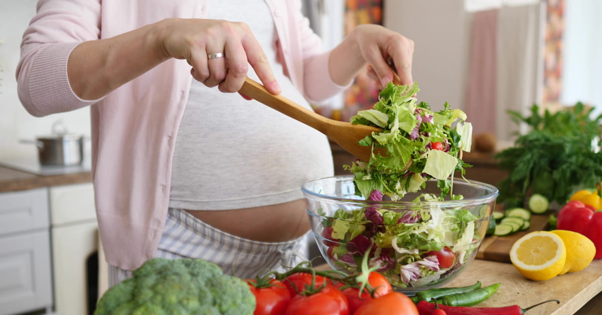 Donna in gravidanza con piatto di insalata