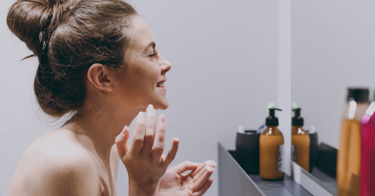 Giovane donna che fa la skincare routine al mattino